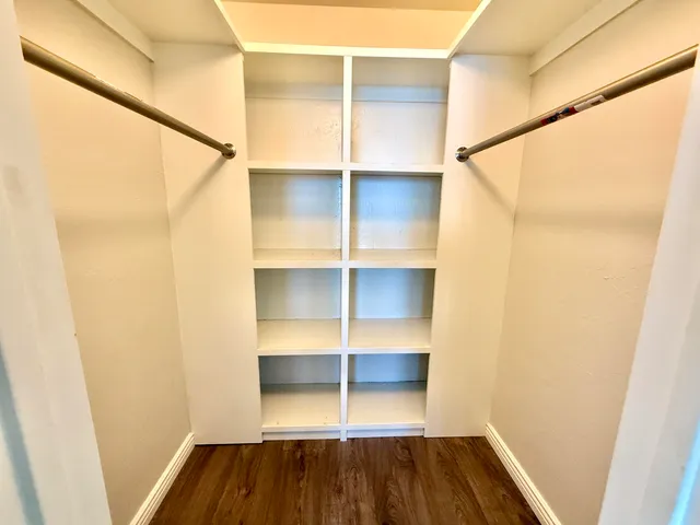 a view of walk in closet with empty racks