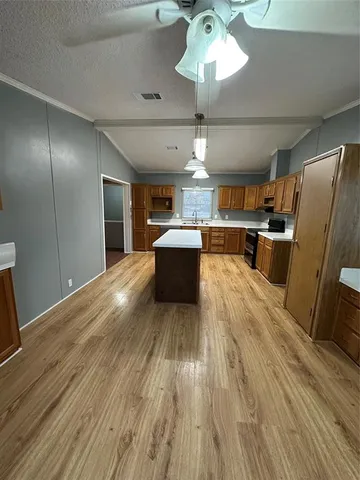 a kitchen with stainless steel appliances a stove refrigerator and wooden floor