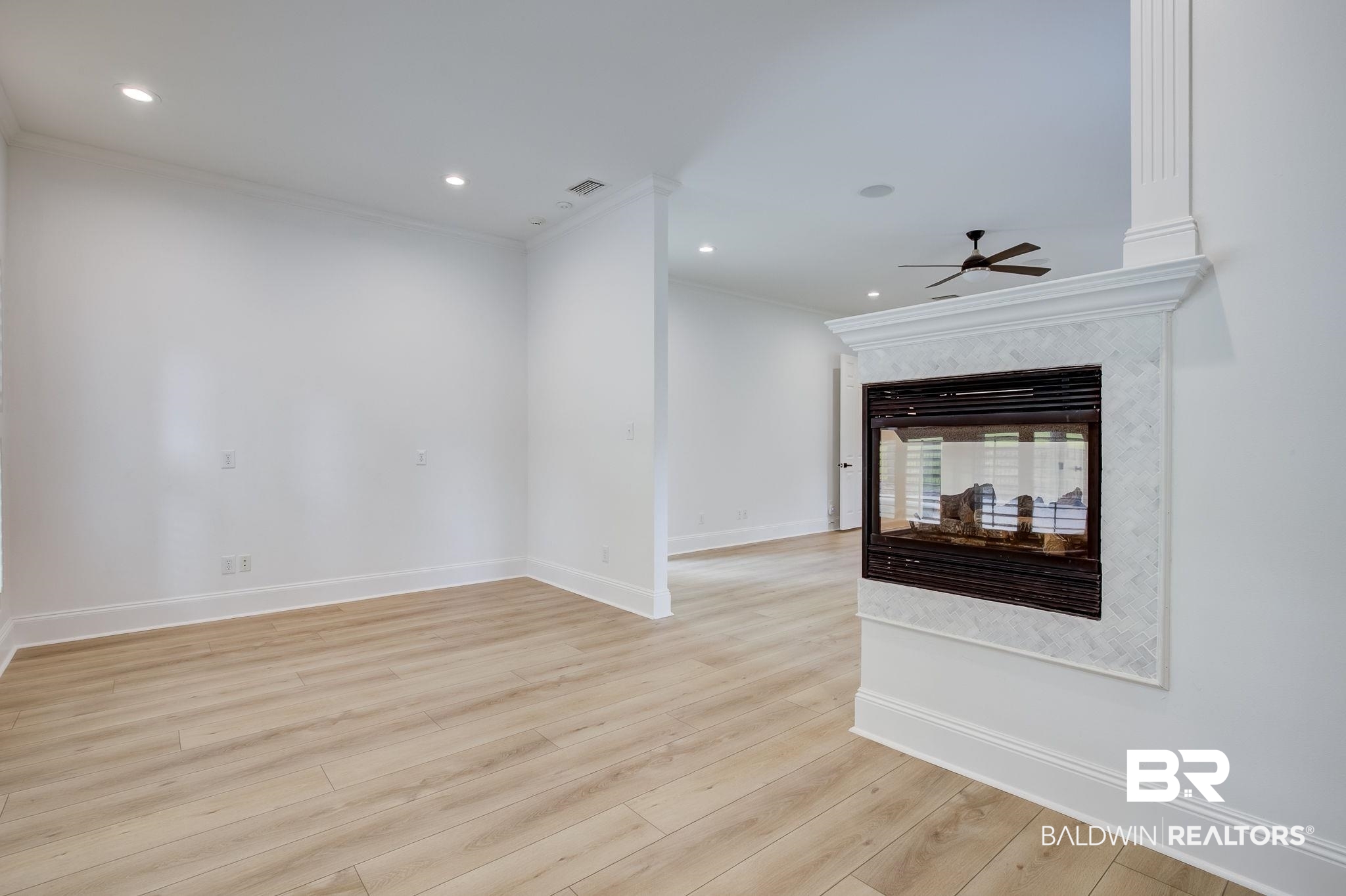 105 High Pines Ridge Fairhope, AL 36532 - Photo 48 of 97 with crown molding, a ceiling fan, baseboards, light wood-style flooring, and a multi sided fireplace