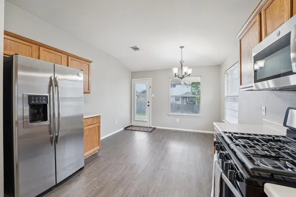 a kitchen with stainless steel appliances granite countertop a refrigerator and a stove top oven