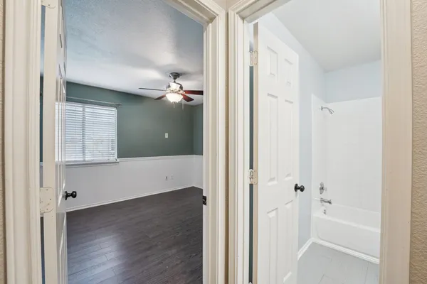 a view of a bathroom with a tub shower and hardwood floor