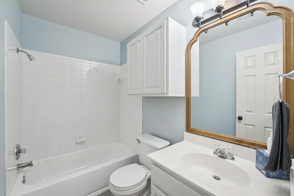 a bathroom with a bathtub shower sink vanity and toilet