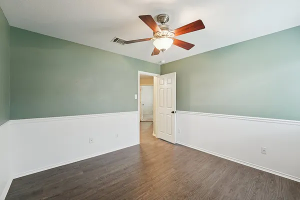 an empty room with wooden floor white walls and white wall