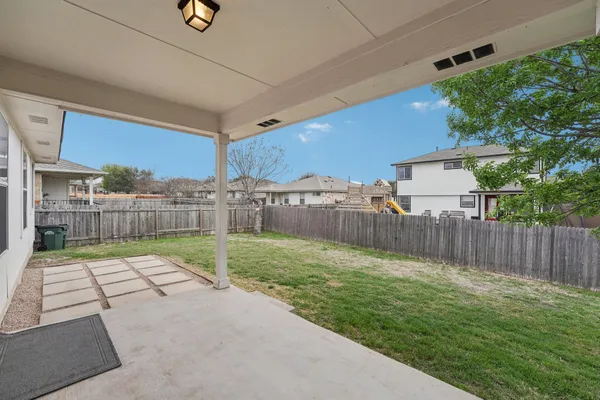 a view of backyard with wooden fence