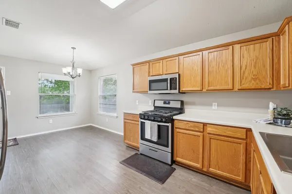 a kitchen with stainless steel appliances granite countertop a stove a sink and a microwave