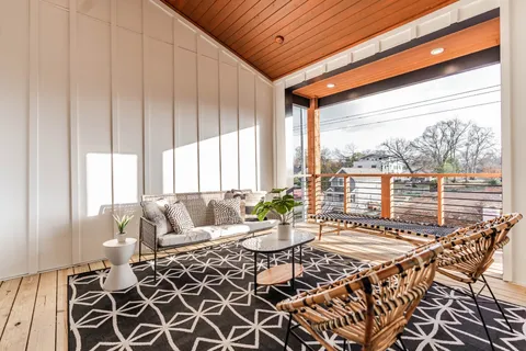a living room with furniture and floor to ceiling windows