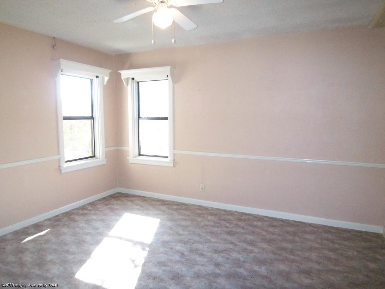 3814 Parker Street Amarillo, TX 79110 - Photo 7 of 13 an empty room with windows and fan