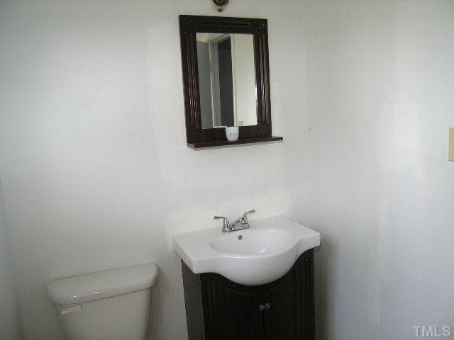 1913 Crawford Road Raleigh, NC 27610 - Photo 11 of 12 a bathroom with a sink a mirror and toilet