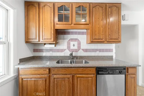 a kitchen with granite countertop a sink and cabinets