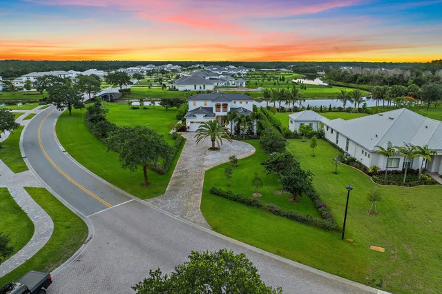a kitchen with stainless steel appliances granite countertop a stove a refrigerator a sink a dining table and chairs