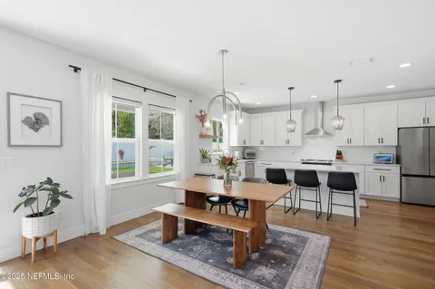 a living room with furniture a dining table and a potted plant