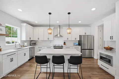 a kitchen with stainless steel appliances a stove a sink island and a refrigerator