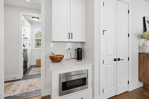a kitchen with stainless steel appliances white cabinets and a fireplace