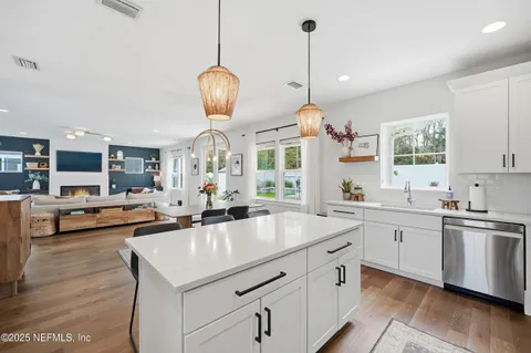 a kitchen with stainless steel appliances granite countertop a sink a stove and a wooden floors