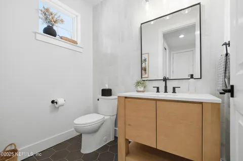 a bathroom with a toilet a sink and mirror