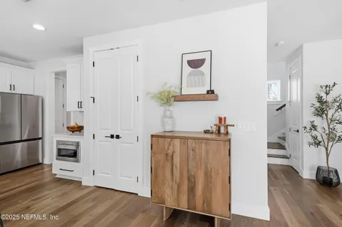 a view of a kitchen with wooden floor and electronic appliances