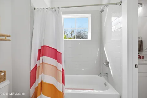 a bathroom with a sink vanity mirror and tub