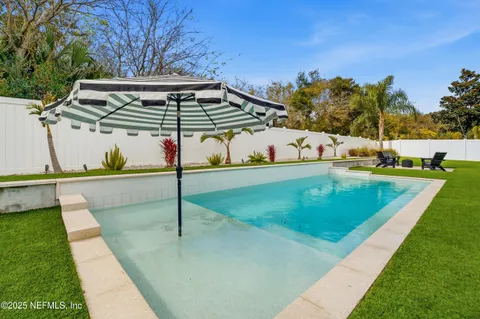 a view of a house with swimming pool and sitting area