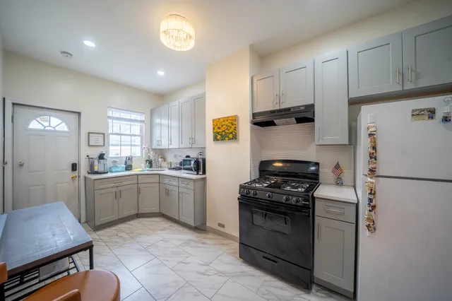 a kitchen with a refrigerator and a stove top oven