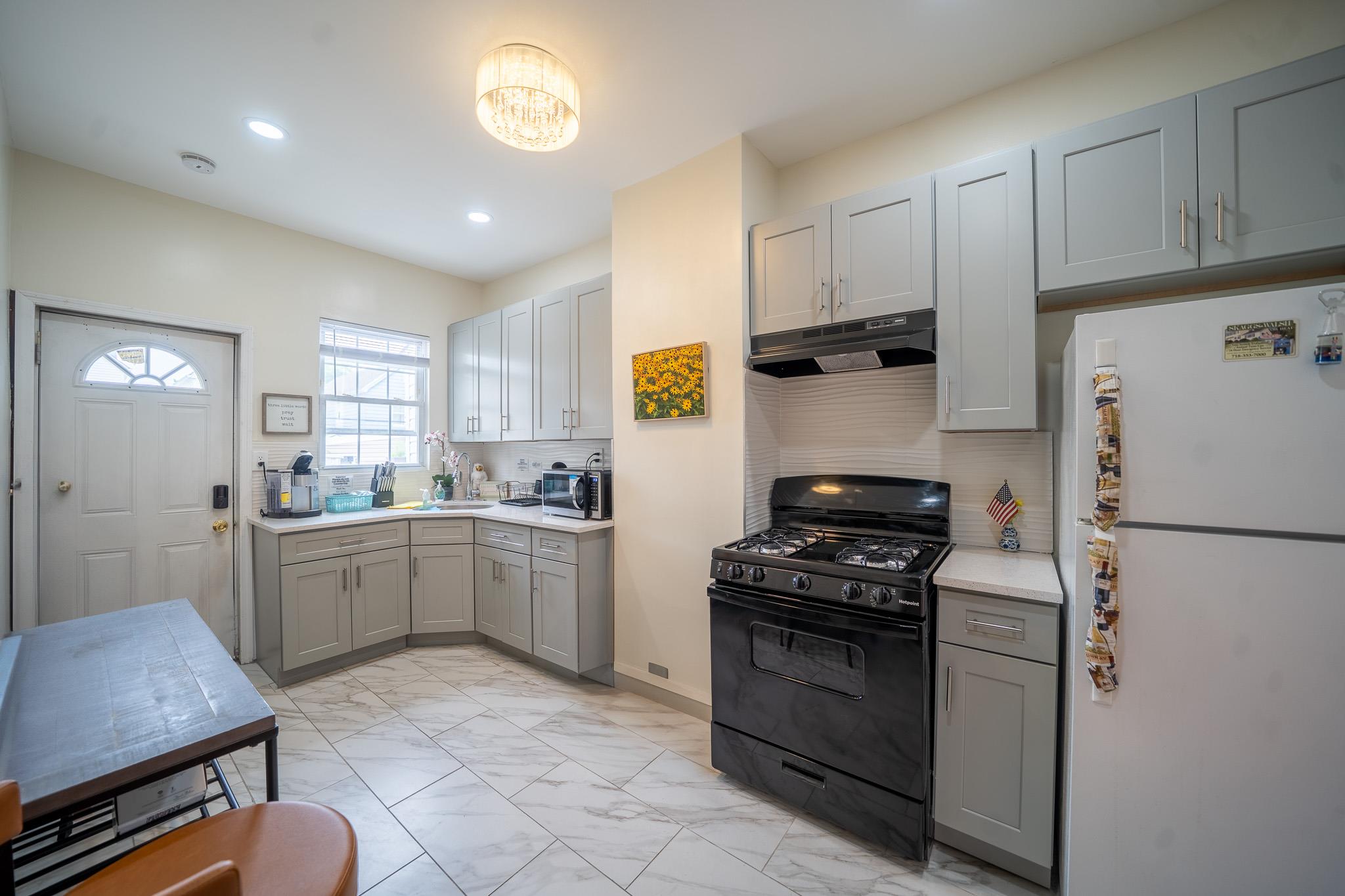 104-21 Lefferts Boulevard Queens, NY 11419 - Photo 11 of 29 a kitchen with a refrigerator and a stove top oven