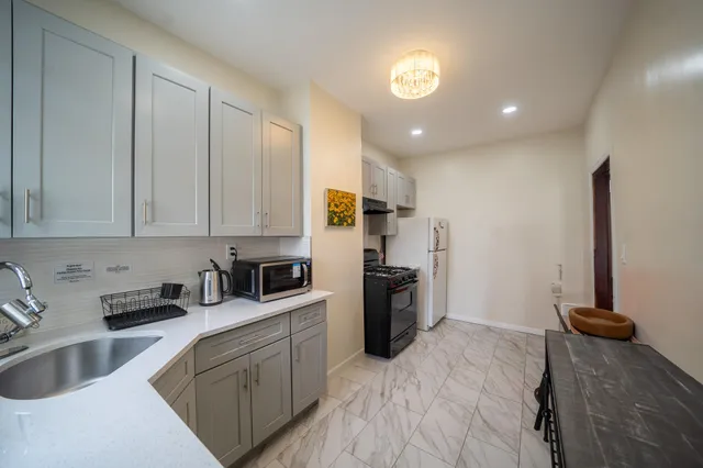 a kitchen with stainless steel appliances granite countertop a refrigerator sink and stove