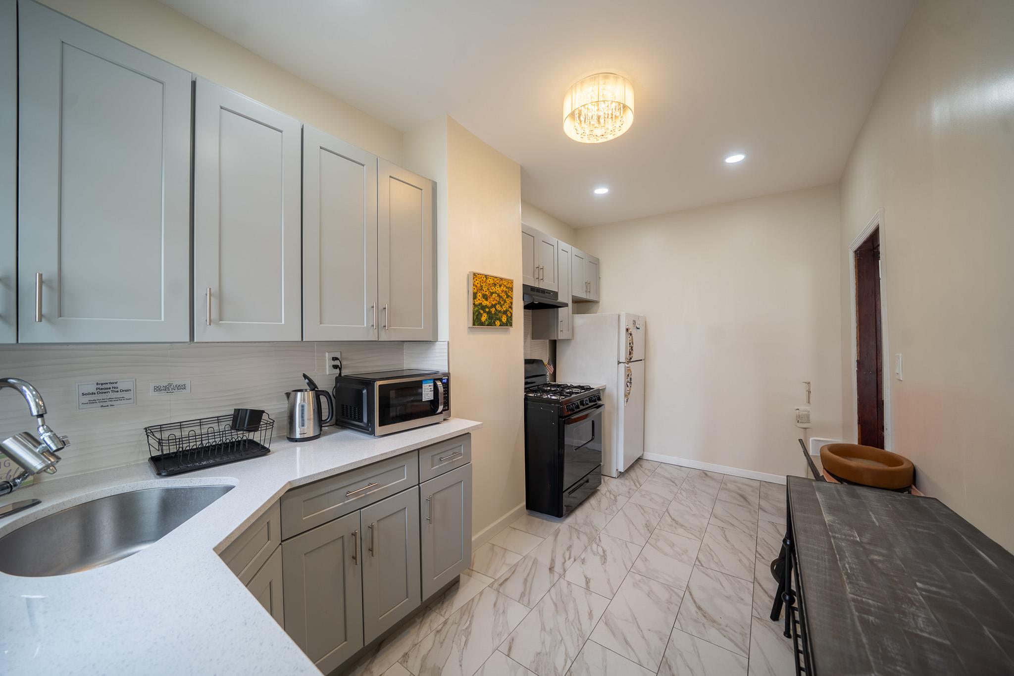 104-21 Lefferts Boulevard Queens, NY 11419 - Photo 12 of 29 a kitchen with stainless steel appliances granite countertop a refrigerator sink and stove