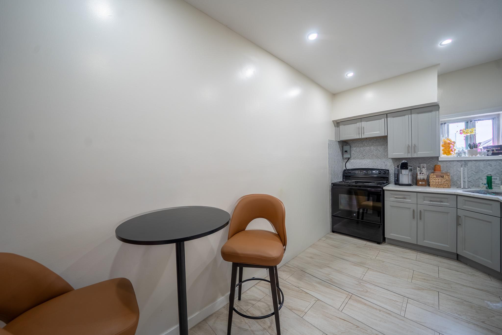 104-21 Lefferts Boulevard Queens, NY 11419 - Photo 17 of 29 a kitchen with stainless steel appliances granite countertop a stove a sink dishwasher and a microwave with wooden floor