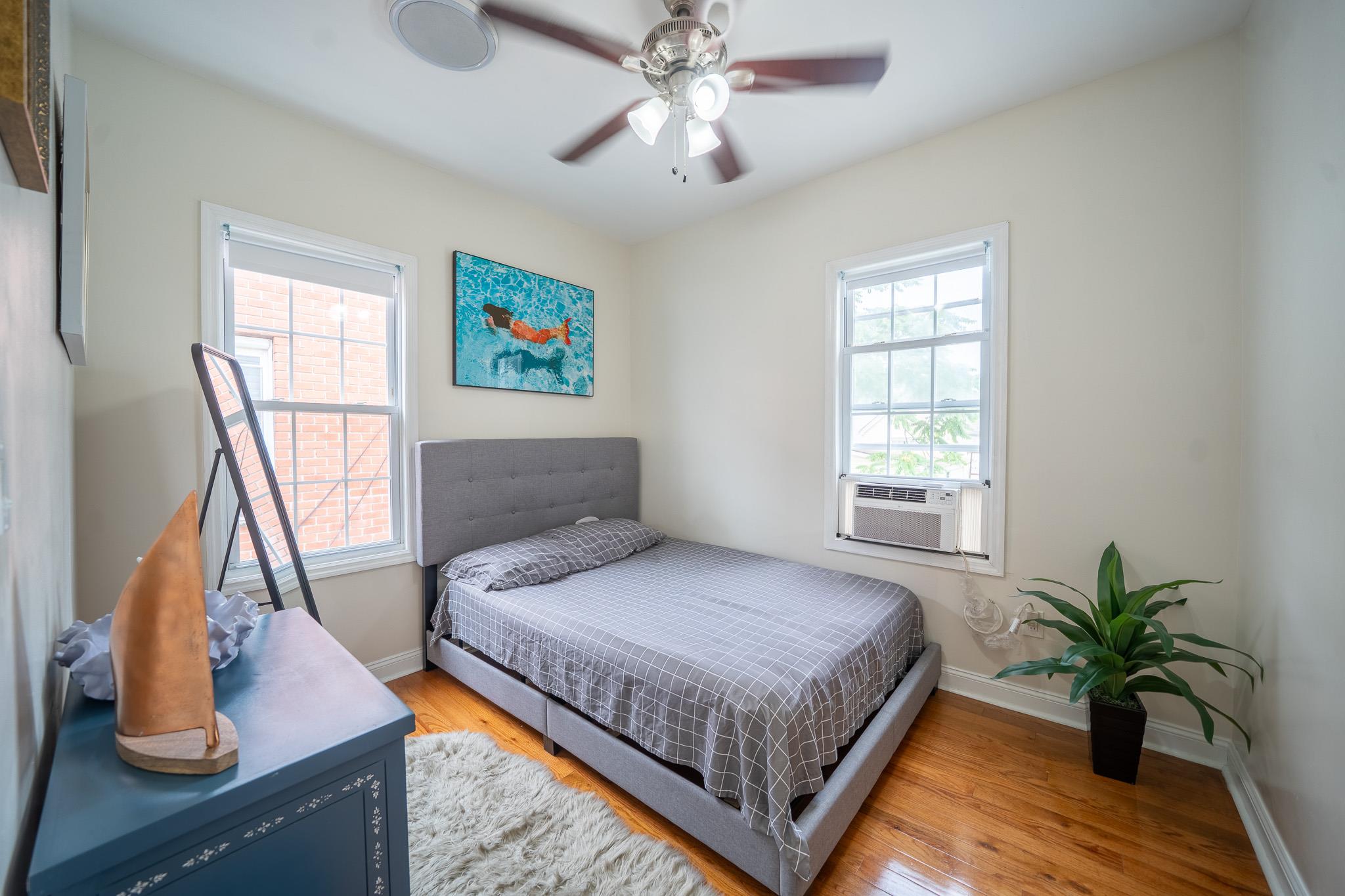 104-21 Lefferts Boulevard Queens, NY 11419 - Photo 20 of 29 a bedroom with a large bed and a chandelier