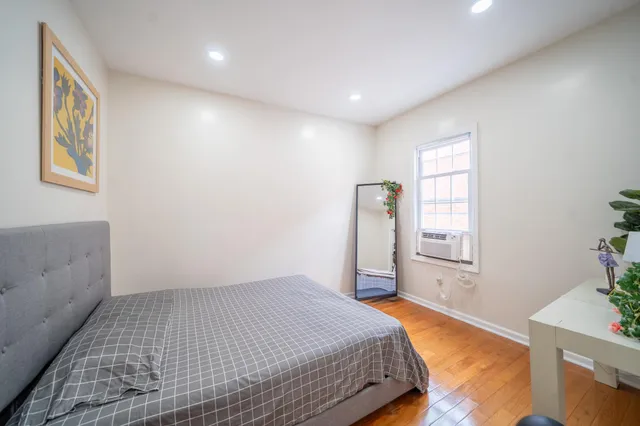 a spacious bedroom with a bed and a potted plant