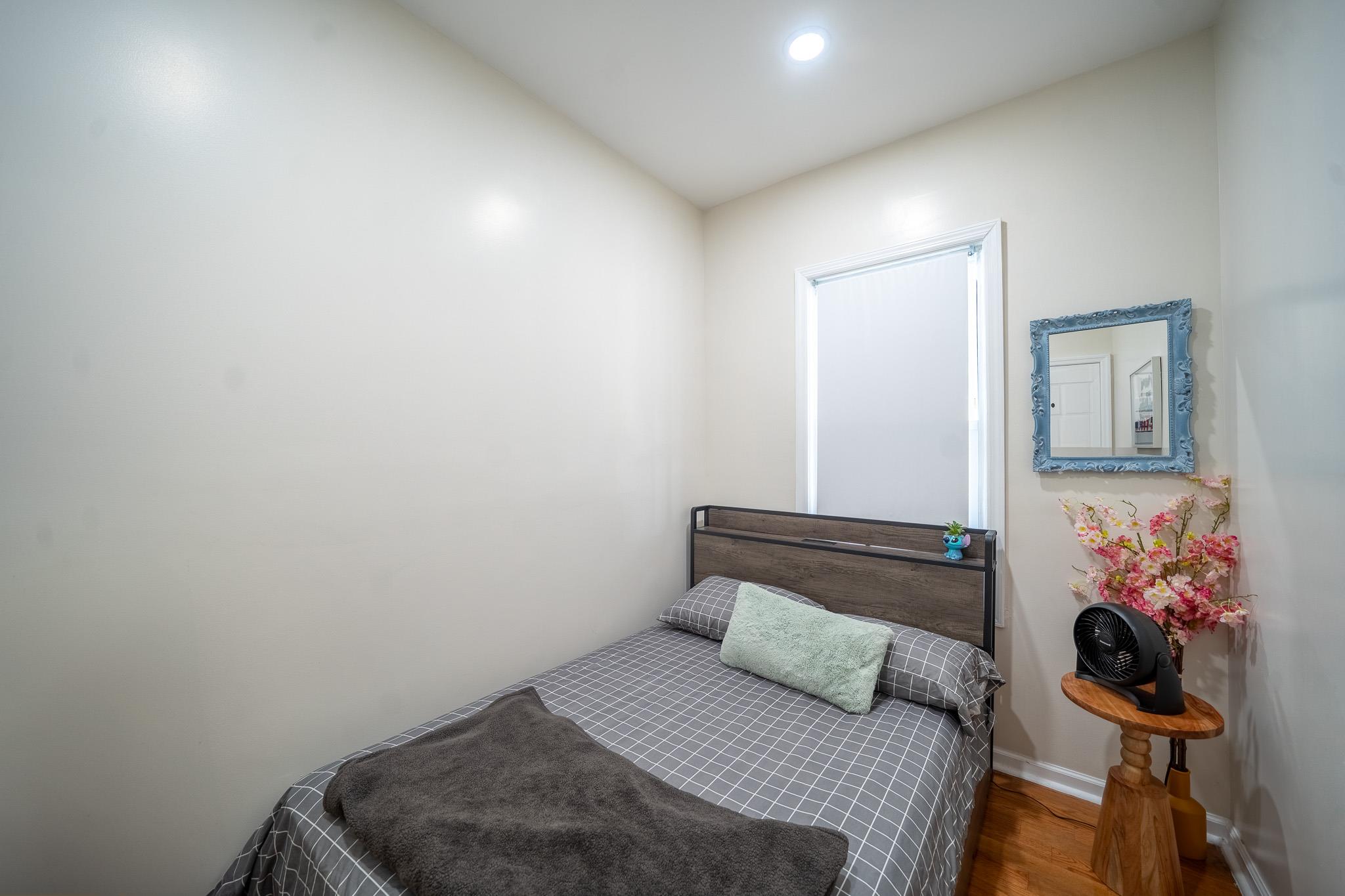 104-21 Lefferts Boulevard Queens, NY 11419 - Photo 23 of 29 a bedroom with a bed and a potted plant