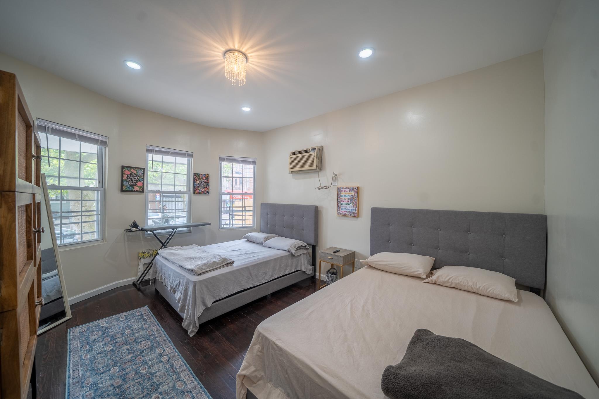 104-21 Lefferts Boulevard Queens, NY 11419 - Photo 7 of 29 a bedroom with two beds and a chandelier