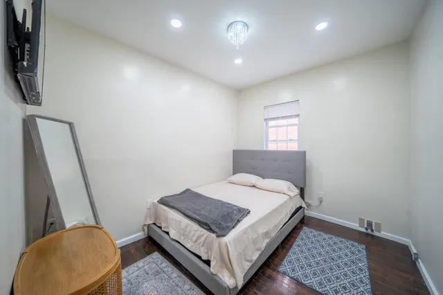 a bedroom with a bed and a lamp with wooden floor