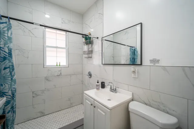 a bathroom with a toilet sink and mirror