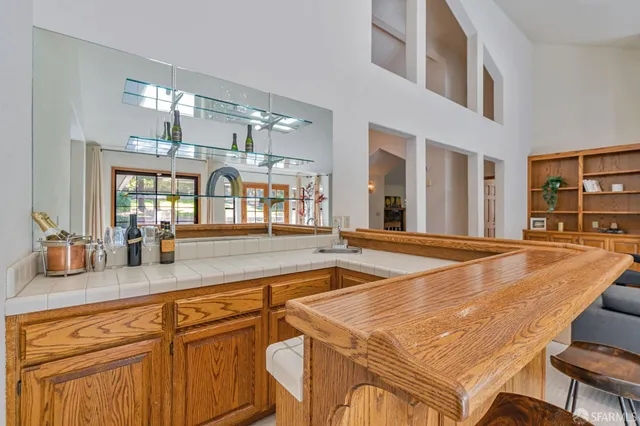 a living room with stainless steel appliances furniture a rug and a kitchen view