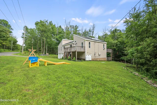 a view of a house with a yard and sitting area