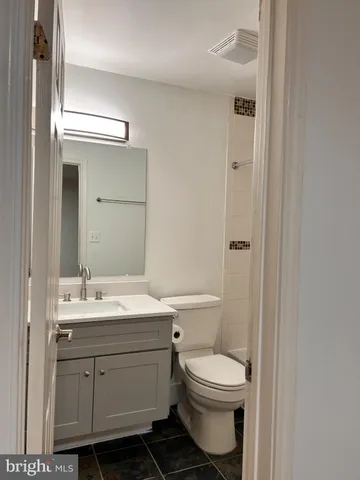 a bathroom with a toilet a sink and mirror