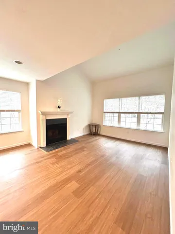 an empty room with wooden floor and fireplace