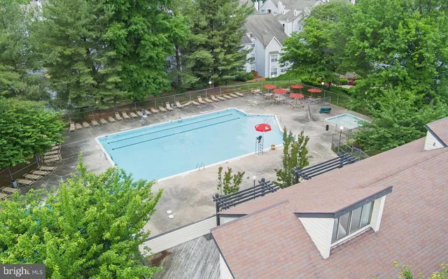 a view of swimming pool with a bench and trees in the background
