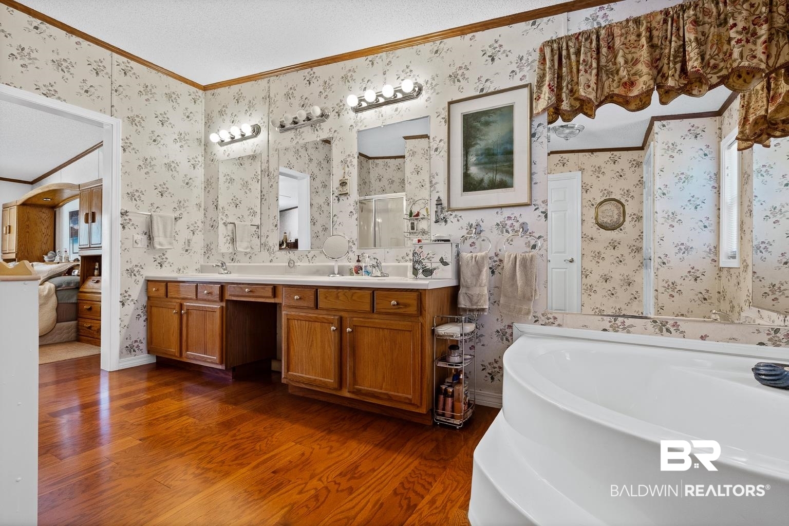10647 Rte Road Lillian, AL 36549 - Photo 48 of 62 Bathroom featuring wood finished floors, crown molding, a bath, and wallpapered walls