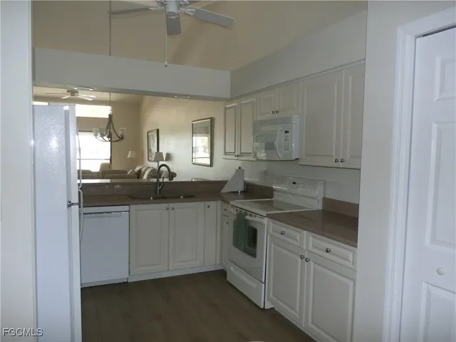 a kitchen with stainless steel appliances granite countertop white cabinets and sink