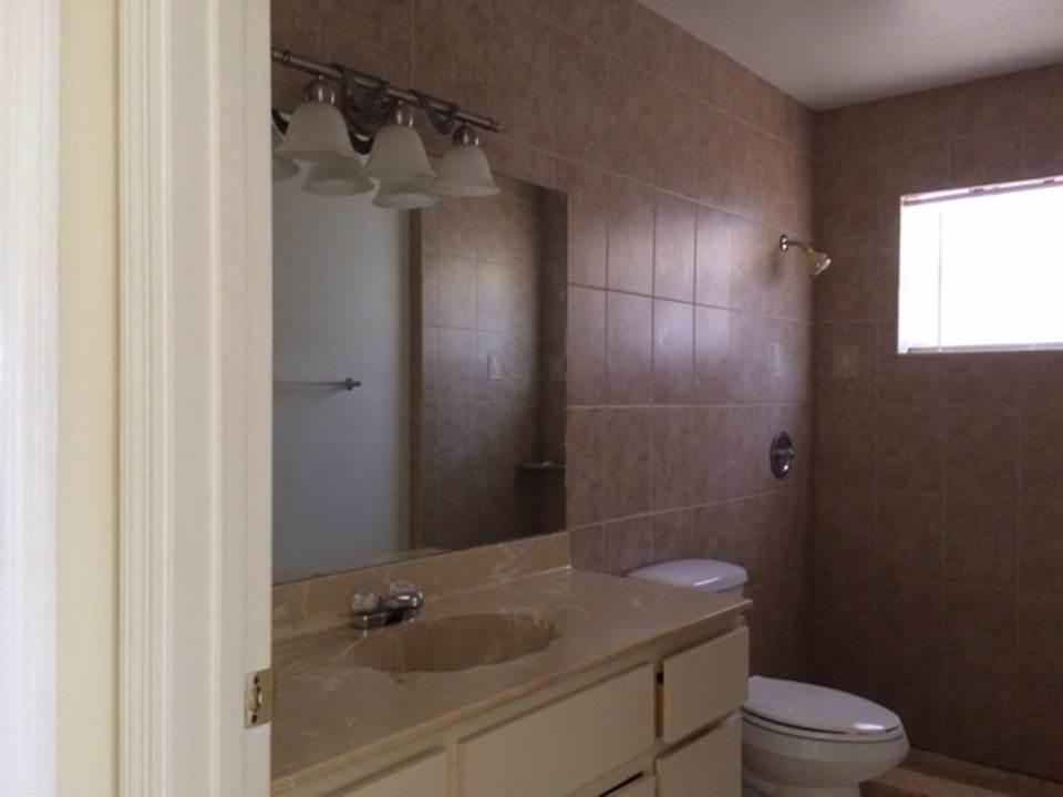 4328 Woodstock Drive, Unit D West Palm Beach, FL 33409 - Photo 6 of 9 a bathroom with a granite countertop sink toilet and shower