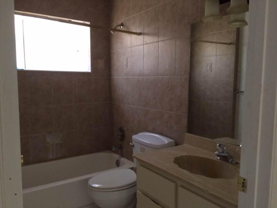 4328 Woodstock Drive, Unit D West Palm Beach, FL 33409 - Photo 8 of 9 a bathroom with a toilet and a bathtub