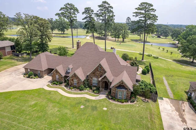 a view of house with swimming pool and a yard