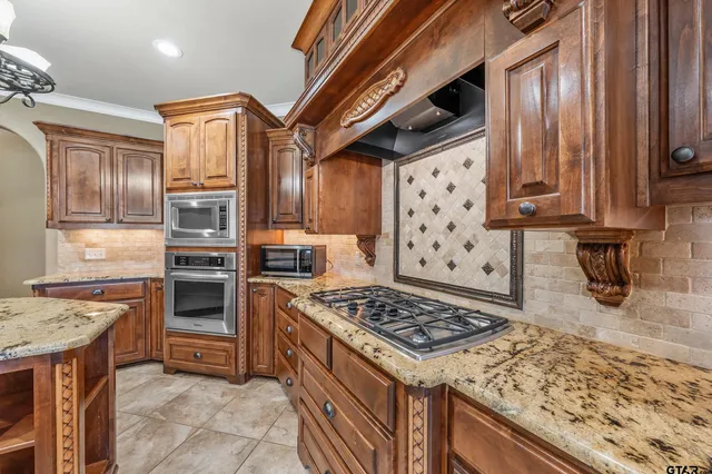 a kitchen with stainless steel appliances granite countertop a stove and a refrigerator