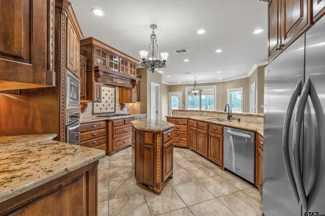 a kitchen with stainless steel appliances granite countertop counter space a sink refrigerator and cabinets