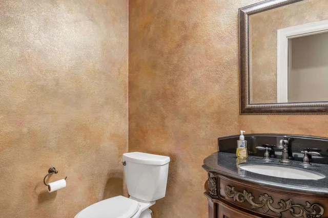 a bathroom with a toilet a sink and mirror