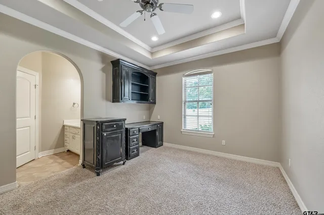 an empty room with windows and ceiling fan
