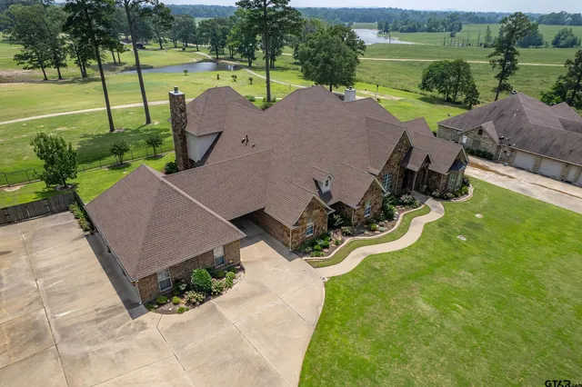 a view of a backyard with large trees and a garden