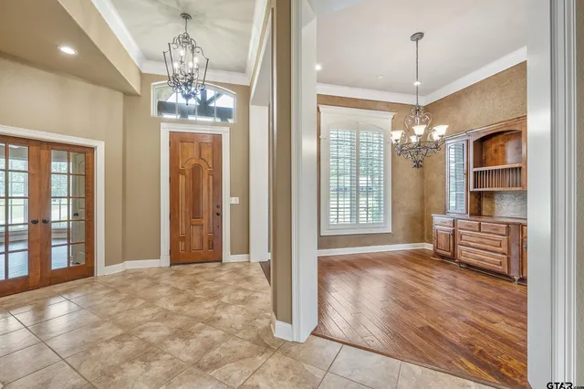 a view of a livingroom with a chandelier curtains and large windows