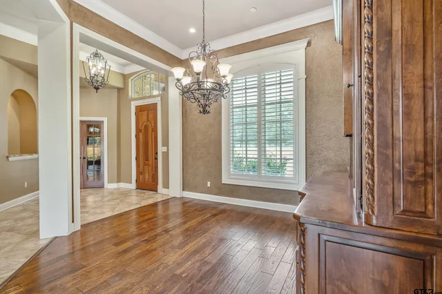 a view of a big room with wooden floor and chandelier